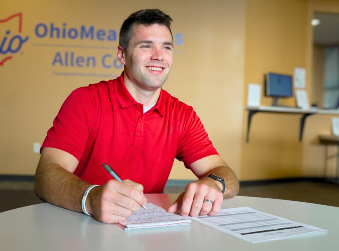 Kyler smiling as he works at a computer